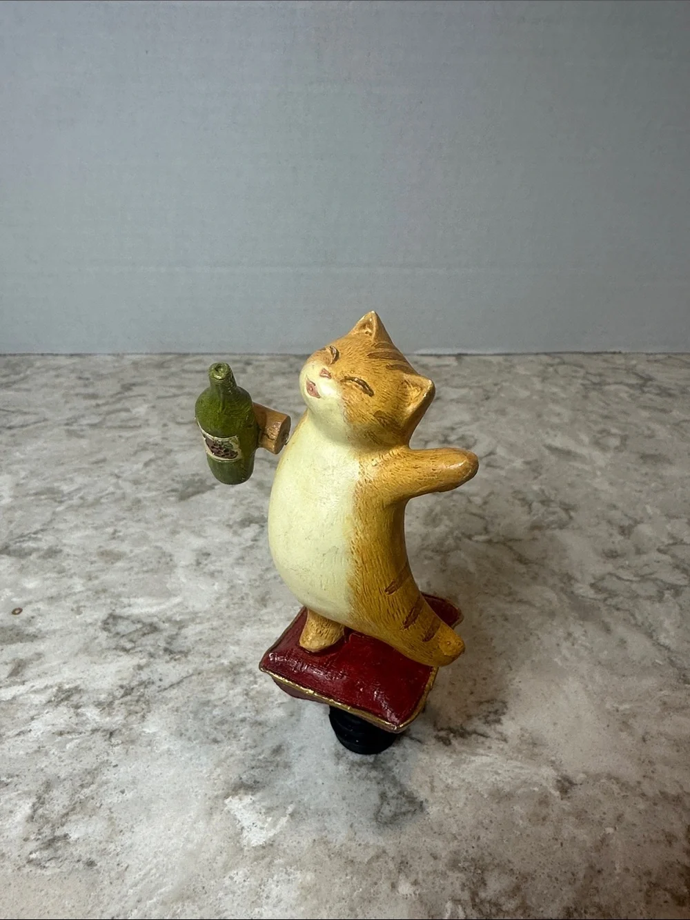 Yellow Cat Figurine Holding Bottle on Red Cushion- Bottle Stopper